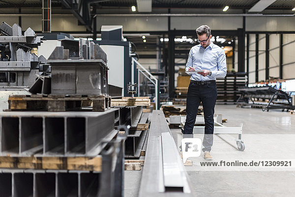 Man with tablet standing on factory shop floor