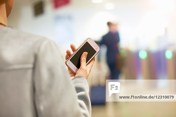 Geschäftsfrau am Flughafen  Smartphone in der Hand  Rückansicht  Mittelteil