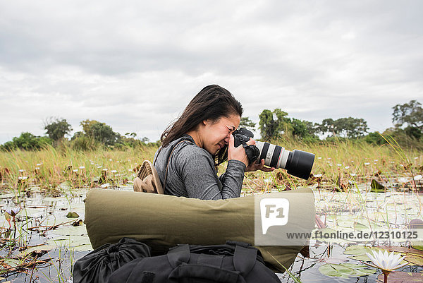 Junge Touristin beim Fotografieren im Okavango-Delta  Botswana  Afrika