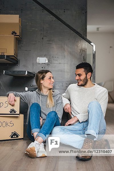 Couple sitting with cardboard boxes  moving home
