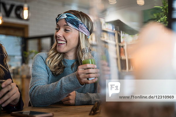 Freundinnen  die im Café sitzen  sich austauschen  Smoothies trinken