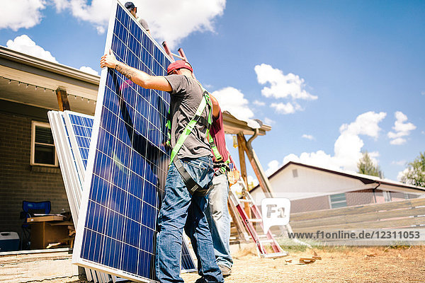 Handwerker  die sich auf die Installation von Solarpaneelen vorbereiten  niedriger Blickwinkel