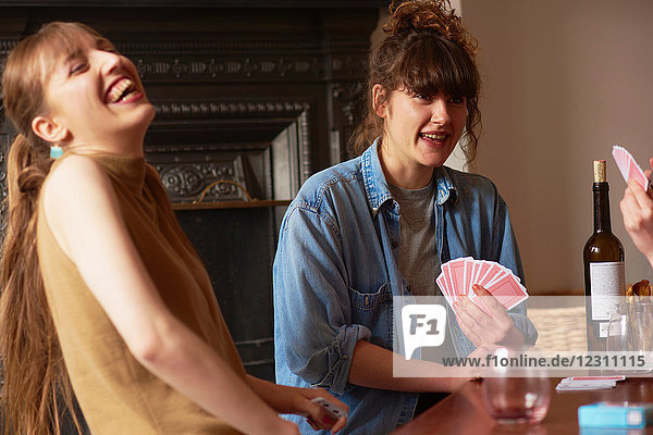 Freunde spielen Karten im Wohnzimmer