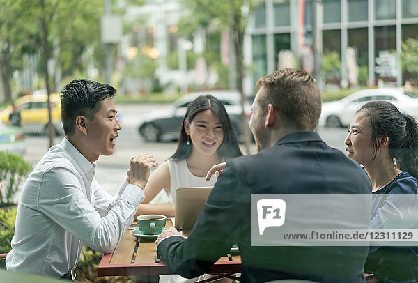 Gruppe von Geschäftsleuten  die sich im Café treffen  Laptop benutzen  im Freien