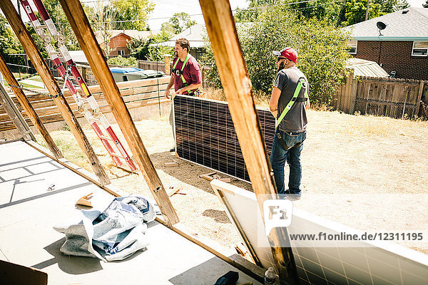 Handwerker  die die Installation von Sonnenkollektoren vorbereiten