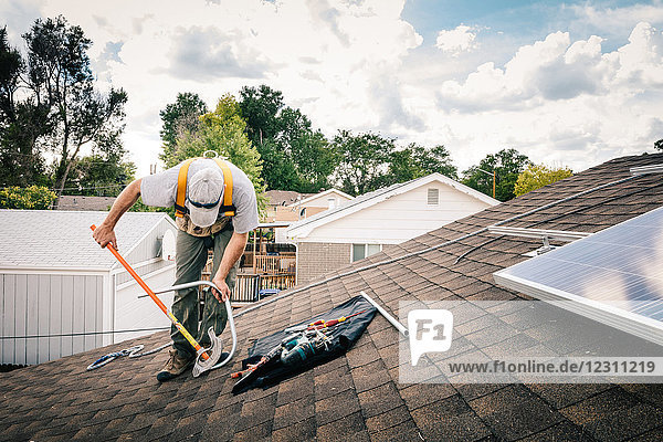 Handwerker installiert Sonnenkollektoren auf dem Hausdach