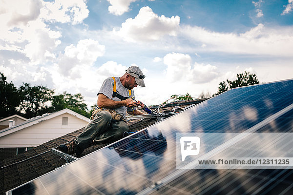 Handwerker installiert Sonnenkollektoren auf dem Hausdach