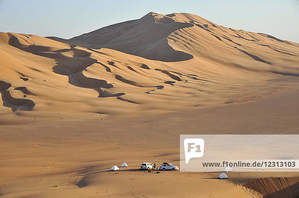 Sultanat Oman  Dhofar  Rub Al Khali Wüste  genannt das leere Viertel  das größte Sandgebiet der Welt  Grenze von Jemen und Saoudi Arabien  ein Touristencampingplatz mit 2 4 Rädern ist verloren in der Mitte einer ockerfarbenen Sandwüste