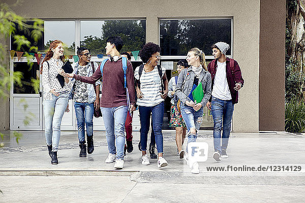 Klassenkameraden  die auf dem College-Campus spazieren gehen und miteinander plaudern