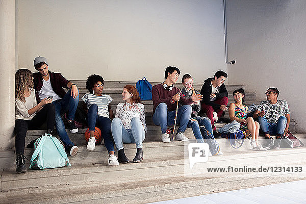 Group of students hanging out and chatting on stairs
