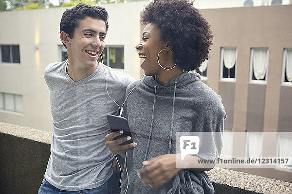 Young couple listening to music together on smart phone