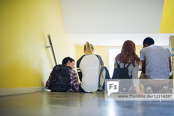 Students sitting together in stairwell  rear view