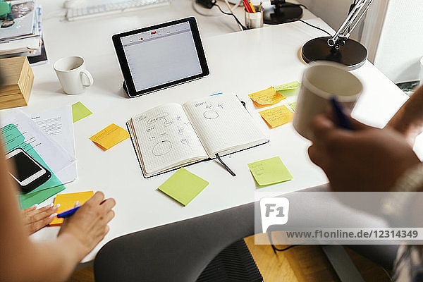 Coworkers standing by desk with notepad