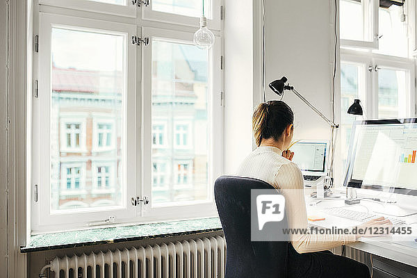 Female editor using computer in office