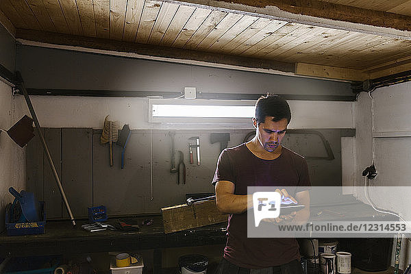 Man using digital tablet in garage