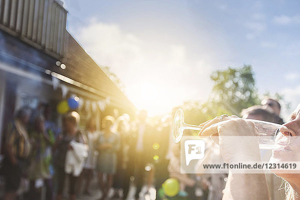 Woman drinking glass of champagne at graduation party