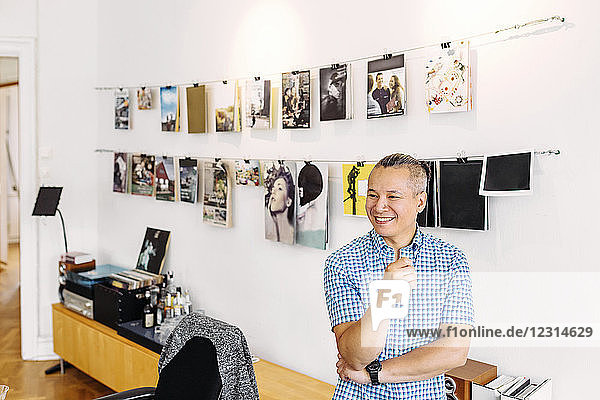Lächelnder Redakteur an einer Wand mit Zeitschriftencovern