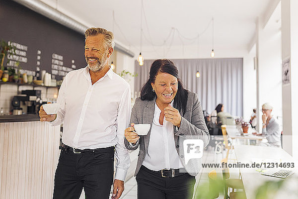 Älterer Mann und reife Frau lachend im Café