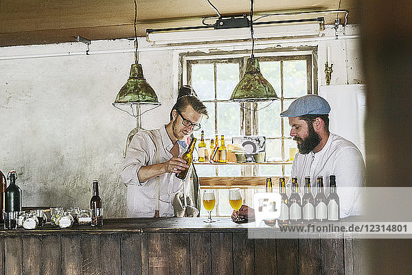 Zwei Männer trinken Bier in einer örtlichen Brauerei