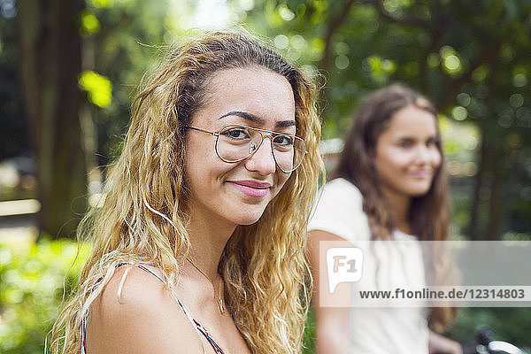 Two teenage girls (14-15) in park