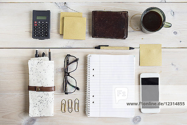 Büromaterial,  Smartphone und Kaffeetasse auf dem Schreibtisch