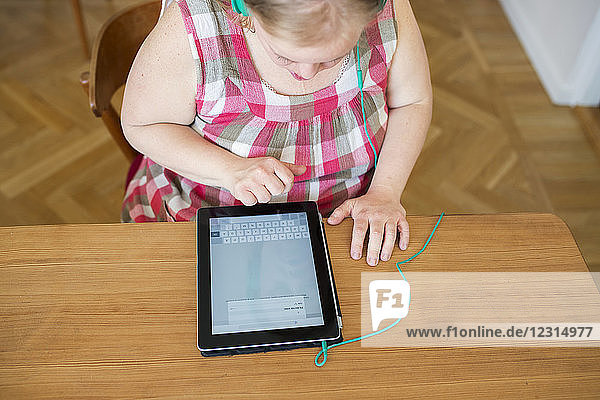 Frau mit Down-Syndrom benutzt digitales Tablet