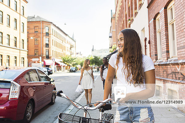 Portrait of teenage girl (14-15) with bicycle
