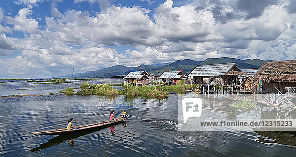 Kela vilage; Shan state  Myanmar (Burma)  Asia ; Stilt houses ; stands in the water ; Local people in a wooden boat paddling on Inle Lake