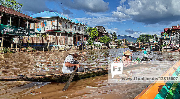 Dorf Thar Lay; Shan-Staat  Myanmar (Burma)  Asien; Stelzenhäuser; steht im Wasser; Einheimische in einem Holzboot paddeln auf dem Inle-See