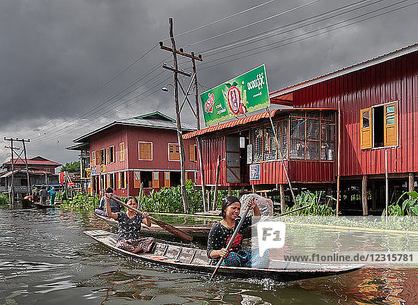 D'IN Dein Stadt; Shan Staat  Myanmar (Burma)  Asien; Stelzenhäuser; steht im Wasser; Einheimische in einem Holzboot paddeln auf dem Inle See