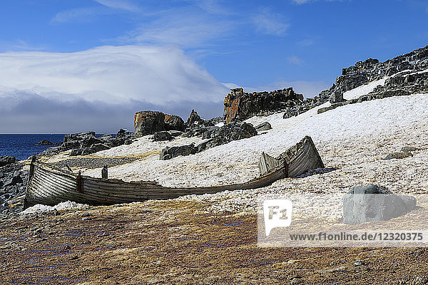 Hübsches  verfallenes Holzboot auf Half Moon Island  verschneite Küste  blauer Himmel und Sonne  Süd-Shetland-Inseln  Antarktis  Polarregionen