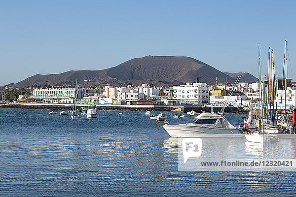 The harbour at Corralejo on the island of Fuerteventura with a volcano in the distance  Fuerteventura  Canary Islands  Spain  Atlantic  Europe