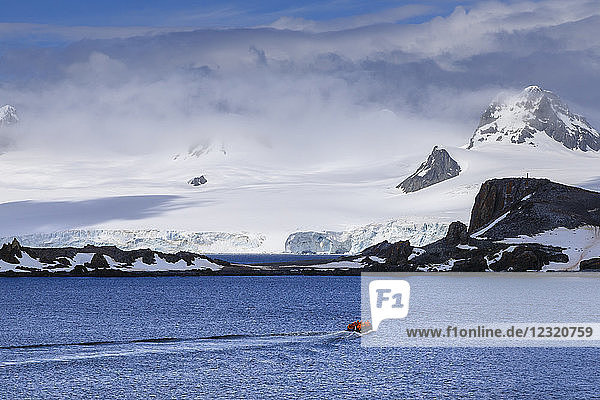 Expedition tourists on a zodiac boat approach Half Moon Island  sunny day  South Shetland Islands  Antarctica  Polar Regions
