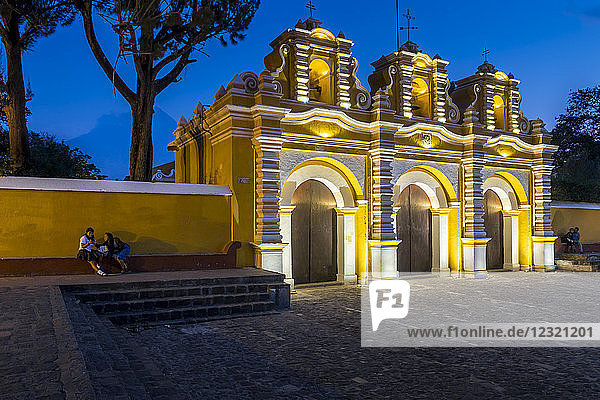 Beleuchtetes Eingangstor der Kapelle El Calvario bei Antigua in der Abenddämmerung  Guatemala  Mittelamerika