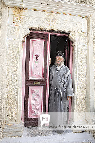 Griechisch-orthodoxer Priester im Eingang des Klosters Moni Taxiarchon  Serifos  Kykladen  Ägäisches Meer  Griechische Inseln  Griechenland  Europa