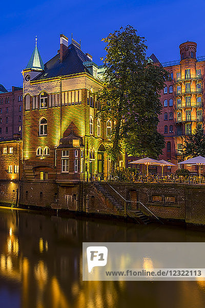 Beleuchtetes Wasserschlösschen-Gebäude in der historischen Speicherstadt in der Abenddämmerung  Hamburg  Deutschland  Europa