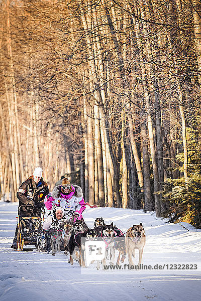 DeeDee Jonrowe und das Schlittenhundeteam laufen durch den Goose Lake Park  Iditarod 2014 Ceremonial Start  Süd-Zentral-Alaska im Winter; Anchorage  Alaska  Vereinigte Staaten von Amerika