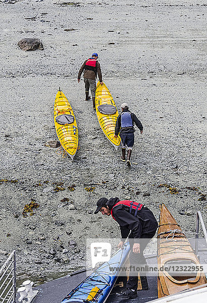 Sea kayakers unloading kayaks from the bow of the boat Baranof Wind  Glacier Bay National Park and Preserve  Southeast Alaska; Alaska  United States of America