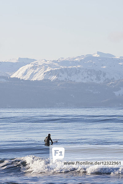 Man surfing in Kachemak Bay  South-central Alaska; Homer  Alaska  United States of America