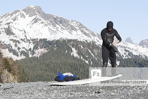 Surfer gearing up to go surfing on the Kenai Peninsula Outer Coast  South-central Alaska; Alaska  United States of America