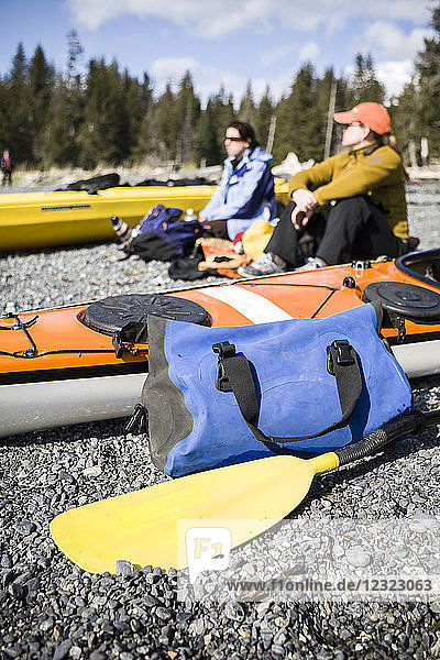 Sea kayakers hanging out on the beach next to boats  Kachemak Bay  South-central Alaska; Alaska  United States of America