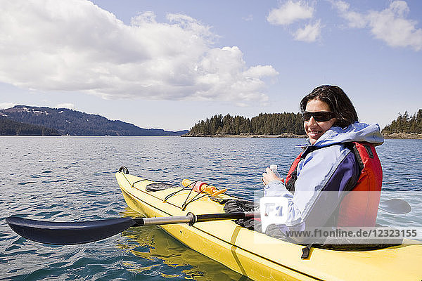 Frau beim Seekajakfahren in der Kachemak Bay  in der Nähe von Homer  Süd-Zentral-Alaska; Alaska  Vereinigte Staaten von Amerika