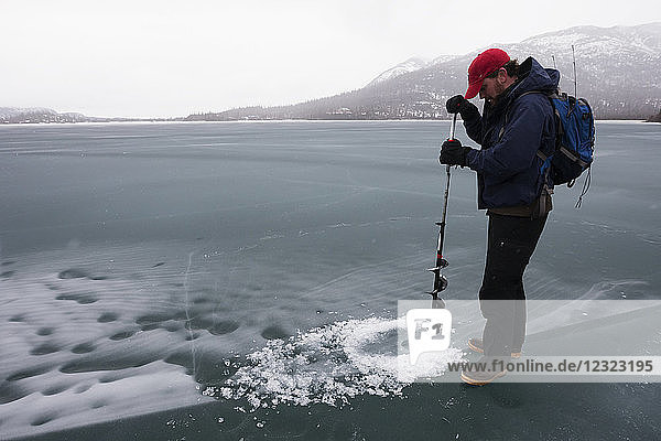 Jäger bohrt Loch für die Robbenjagd  Lake Iliamna  Pedro Bay  Süd-Zentral-Alaska; Alaska  Vereinigte Staaten von Amerika