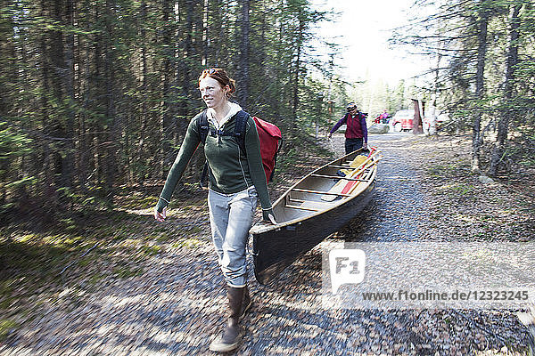 Zwei Frauen transportieren ein Kanu im Swanson Lake  Kenai-Halbinsel  Süd-Zentral-Alaska; Alaska  Vereinigte Staaten von Amerika