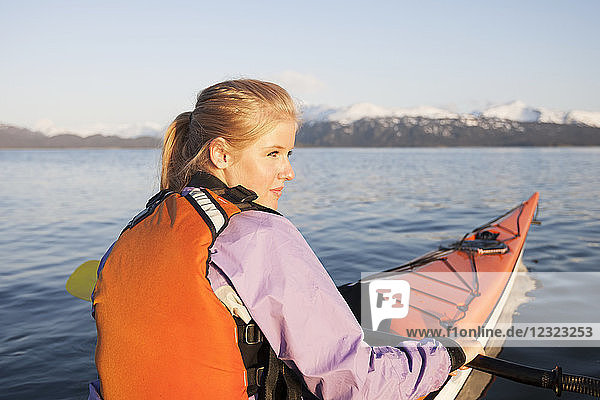 Junge Frau beim Seekajakfahren in der Kachemak Bay  in der Nähe von Homer  Süd-Zentral-Alaska; Alaska  Vereinigte Staaten von Amerika