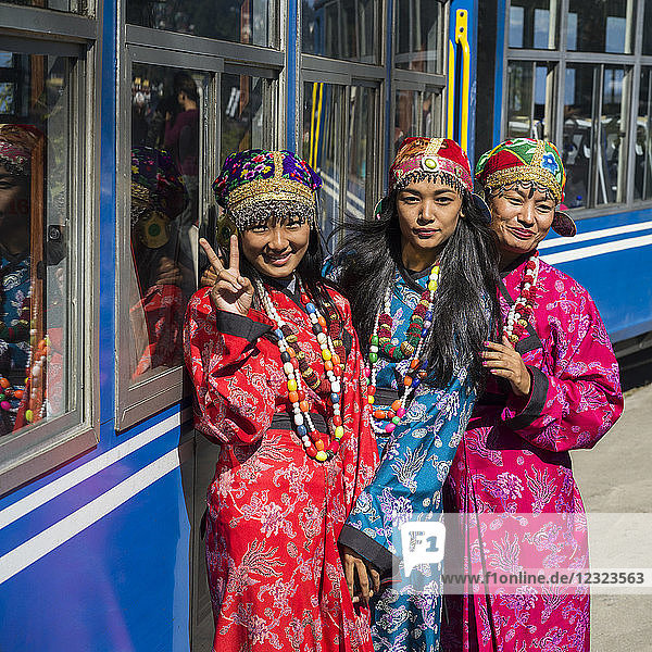 Drei Frauen in Kimonos posieren vor dem Darjeeling Toy Train  Darjeeling Himalayan Railway; Darjeeling  Westbengalen  Indien
