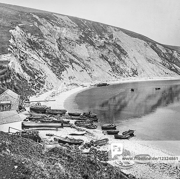 Fischerdorf an der Lulworth Cove mit Booten am Ufer und Klippen entlang der Küste  um 1900; Devon  England