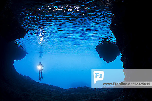 Diver at the entrance to a cavern off the island of Gato  Bohol Sea  Philippines