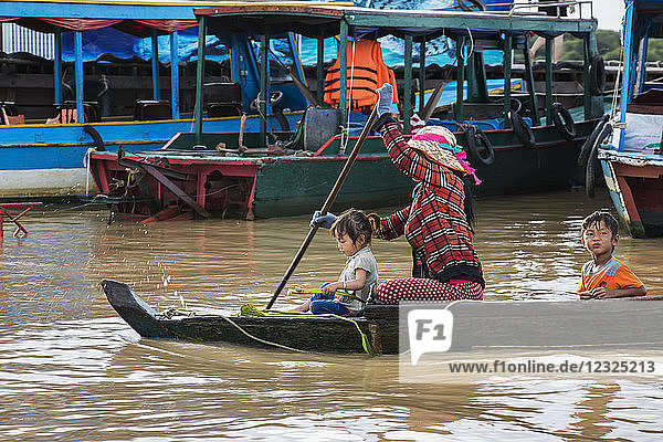 Woman and children in a boat on the Tonle Sap; Siem Reap  Cambodia