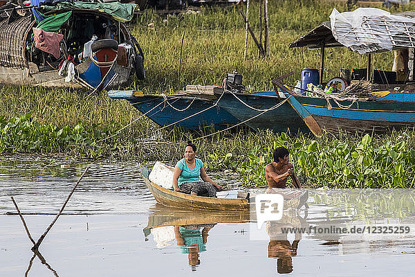 Mann und Frau in einem Boot bei einem schwimmenden Dorf auf dem Tonle Sap; Siem Reap  Kambodscha